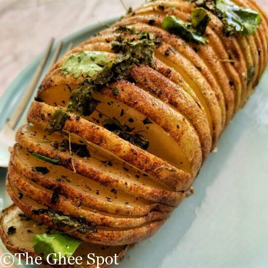 Baked hassleback potato with fenugreek, olive oil, cumin, salt, and pepper.