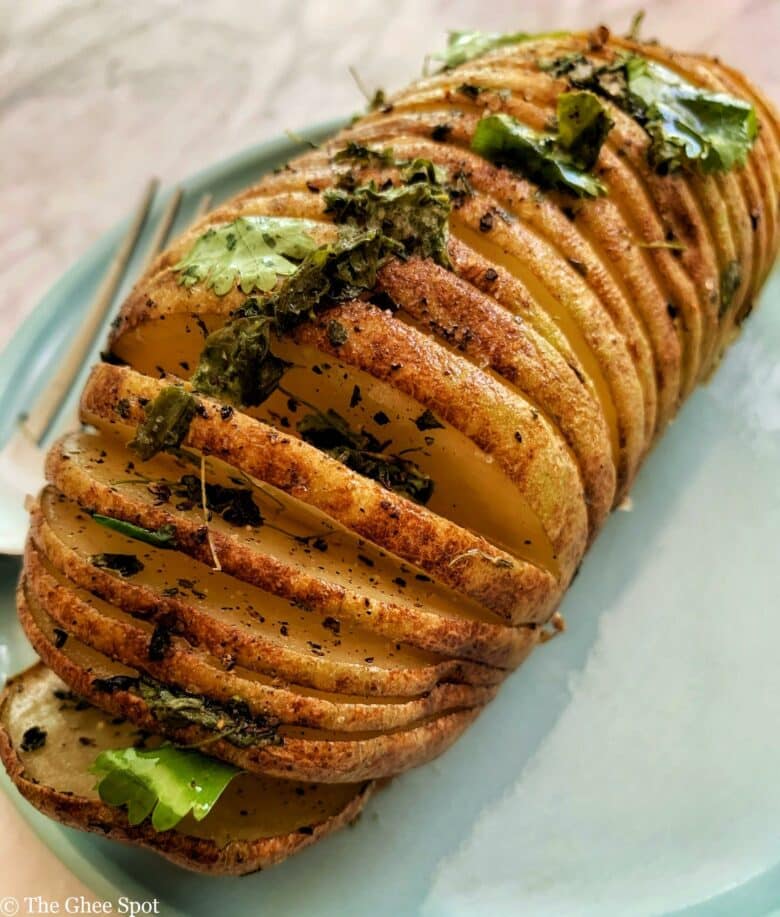 Baked hassleback potato with fenugreek, olive oil, cumin, salt, and pepper.