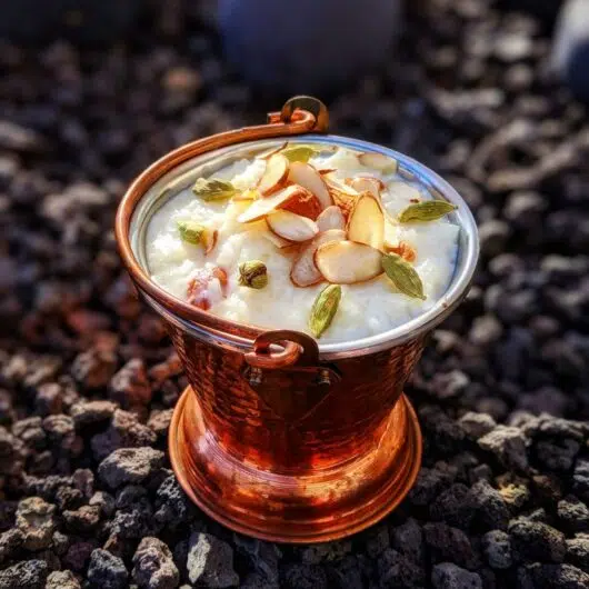 Creamy, sweet, kheer (rice pudding) cooked with whole milk, sugar, cardamom, topped with sliced almonds.
