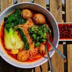Spicy, savory, delicious Chongqing Noodles with bok choy, mushrooms, shrimp, chili oil, and noodles.