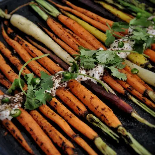 Savory grilled carrots with a cumin yogurt are perfect for an appetizer, snack, or side to a midweek or Thanksgiving dinner.