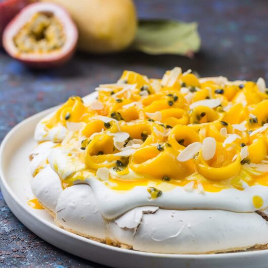 Rosewater pavlova with fresh cream, mango, and passionfruit syrup