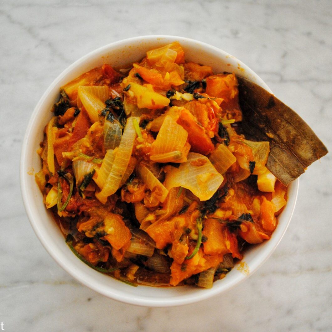 Spicy stewed tomatoes with onion, cilantro, and peppers into a delicious tamatar sabji