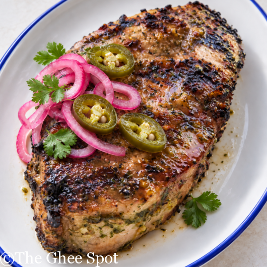 jalepeno pork chop garnished with pickled shallots and jalepenos.